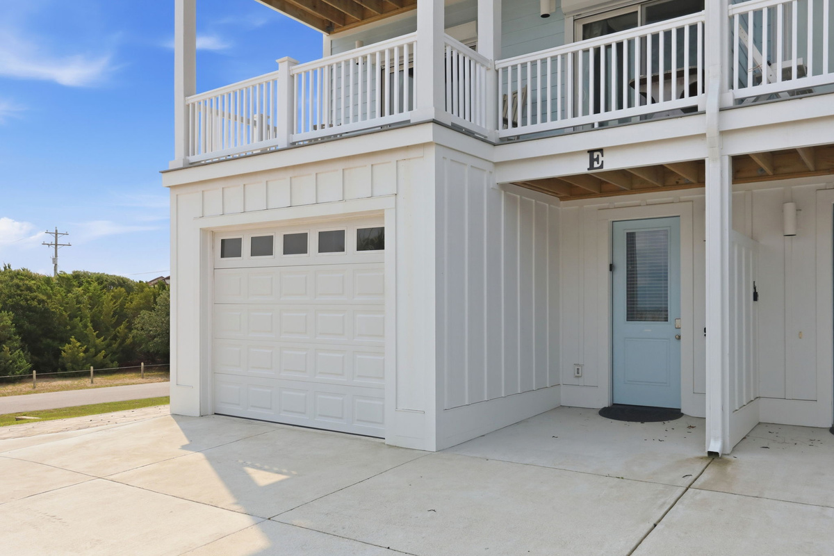 A beautiful coastal home exterior featuring spacious balconies, covered outdoor areas, and easy-access parking