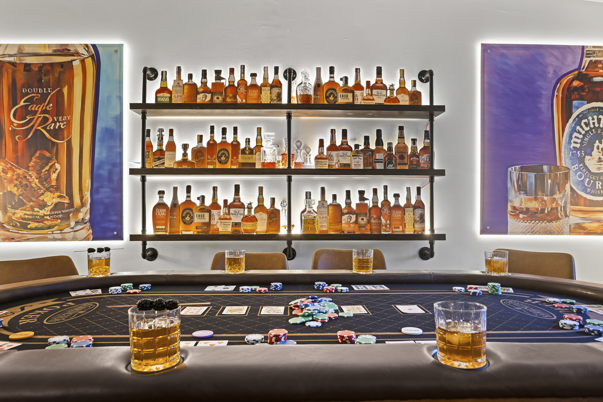 Deal in at the tournament-style poker table with 60+ bottles of bourbon keeping watch from the shelves behind.