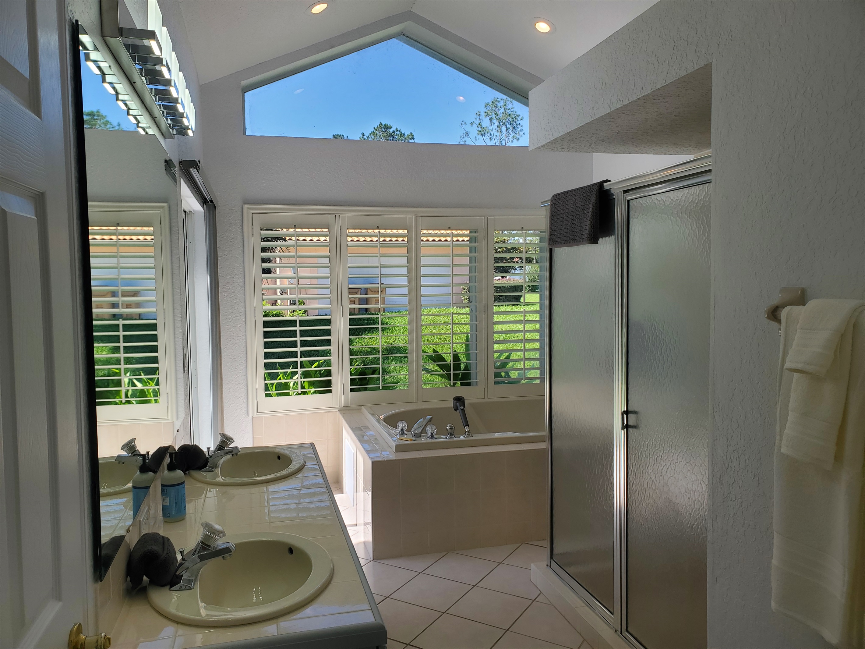 King ensuite bathroom with walk in shower, double sinks, jet tub and toilet
