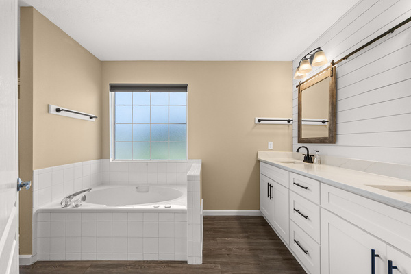 Your private vacation oasis. Unwind after a long day in the deep, jetted jacuzzi tub, perfectly situated under a frosted window that lets in beautiful natural light while maintaining total privacy.