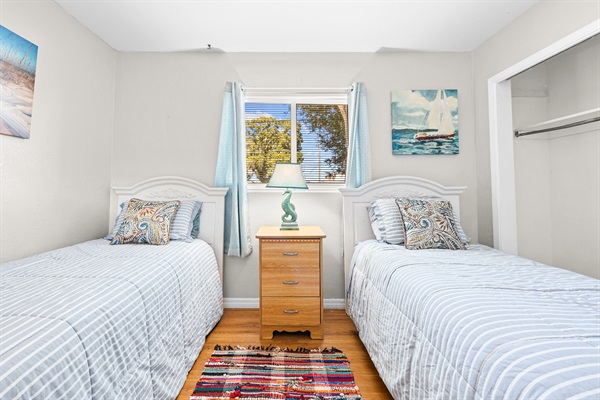 Sand Dollar Room with Two twin beds with linens, a dresser and two closets. 