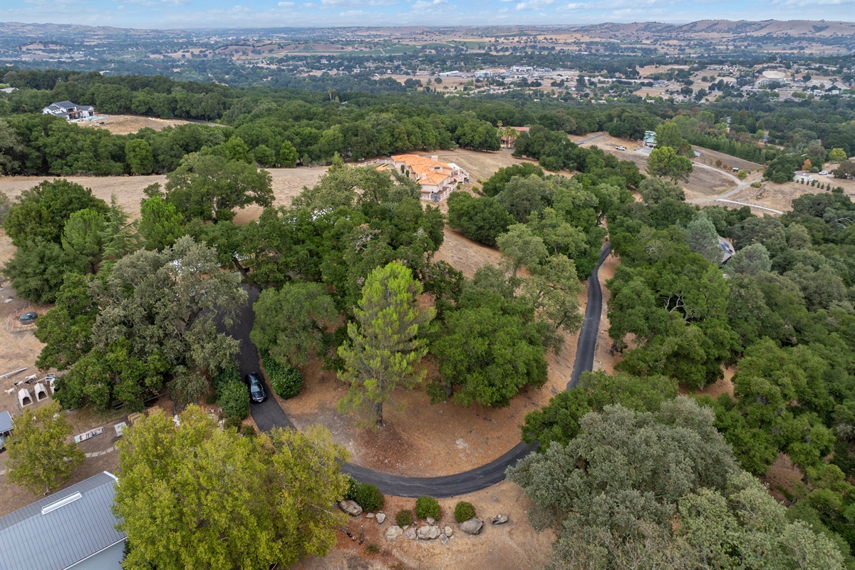 Discover a tranquil hilltop escape, where lush greenery, rolling hills, and a curving country lane set the scene for your stay.