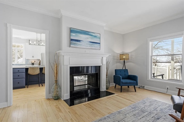 A showstopping live-edge table, from The Furniture House, anchors this spacious lakeview gathering area, offering seating for 14 to enjoy meals, drinks, games, and sunset conversations together.