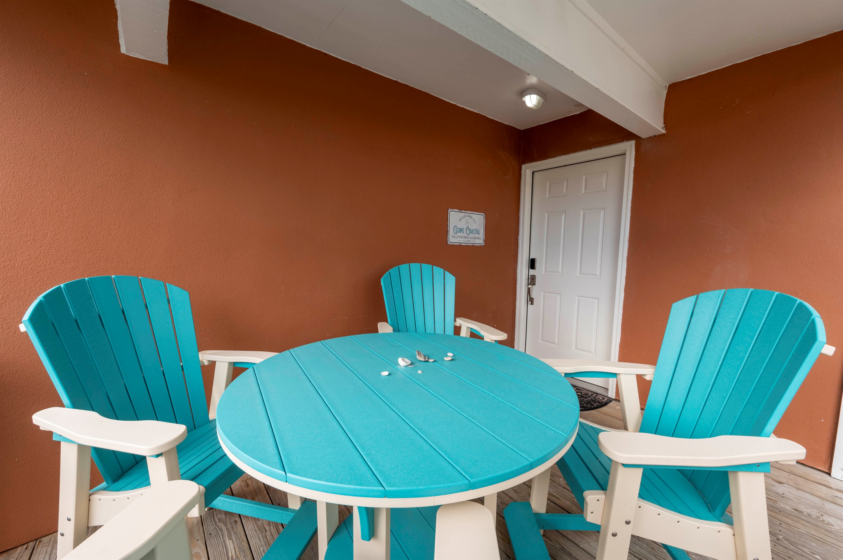 Gone Coastal’s unique turquoise porch furniture - a cheerful, welcoming touch at the front entry.