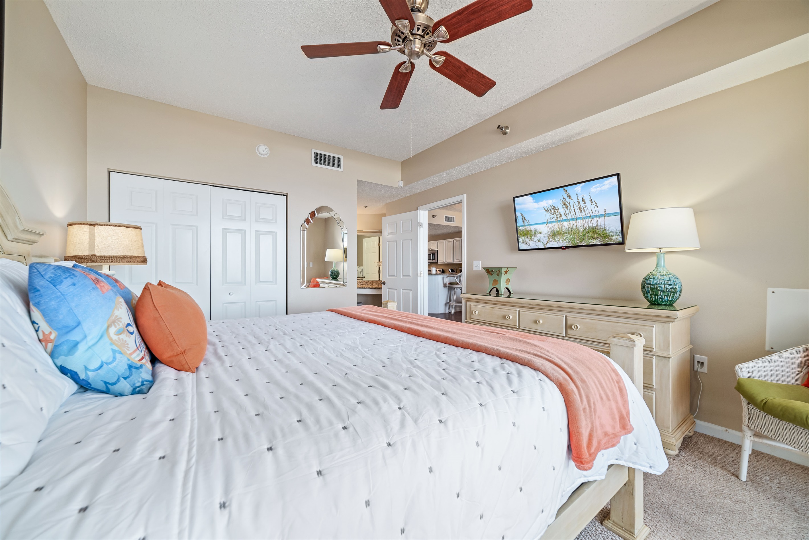 This charming bedroom offers a comfortable bed with vibrant linens, complemented by practical storage solutions. A delightful space to unwind.