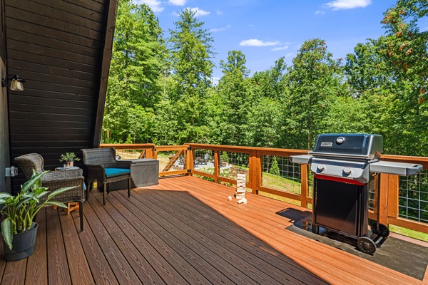 The main deck off the living room and dining spaces is perfect for grilling and alfresco dining. Outfitted with a gas grill and a dining set that can seat 6 people comfortably. From this deck you can enjoy views of the backyard, trees and the firepit.