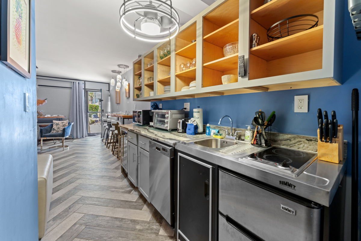 Well appointed efficiency kitchen with mini-fridge, microwave, dishwasher, and beverage fridge.