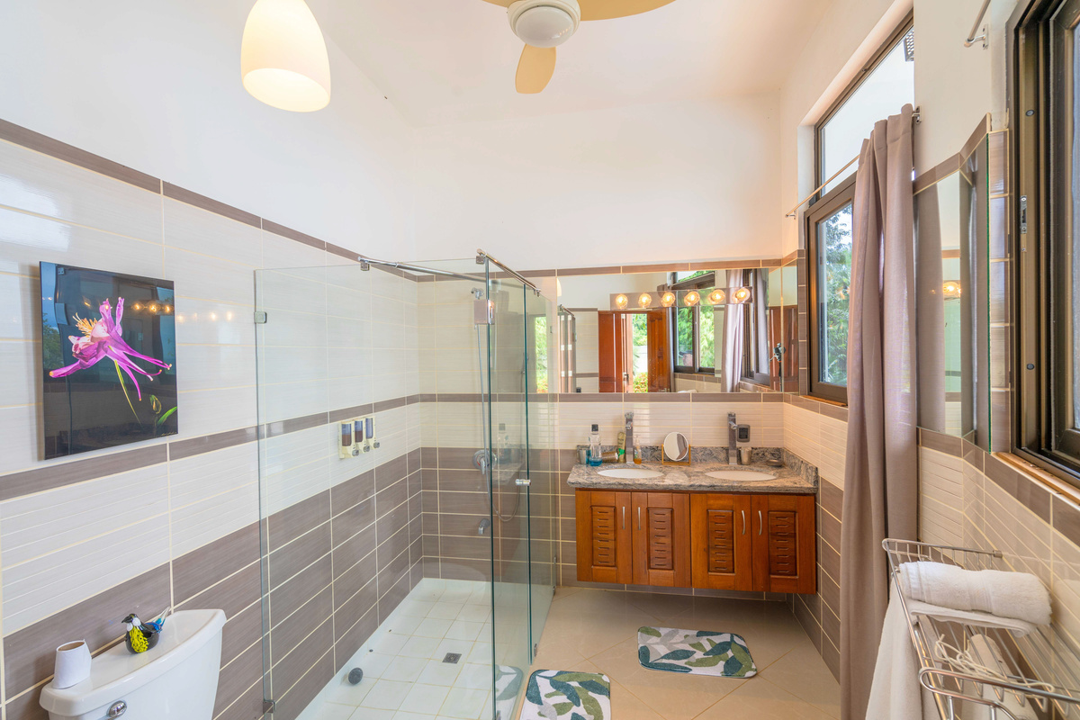 Private ensuite bathroom with glass-enclosed shower and double vanity