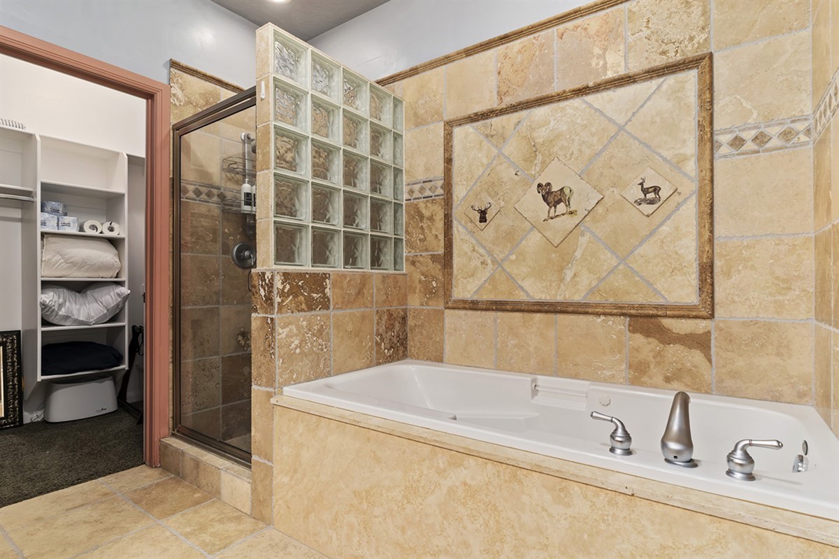 Indulge in a deep soaking tub surrounded by sophisticated tilework, creating a private sanctuary reminiscent of a high-end retreat.