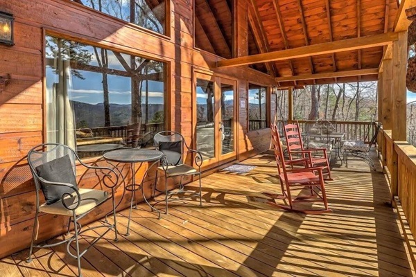 Sun-drenched terrace overlooking the mountains, featuring rocking chairs and outdoor seating for relaxing in the fresh mountain air.