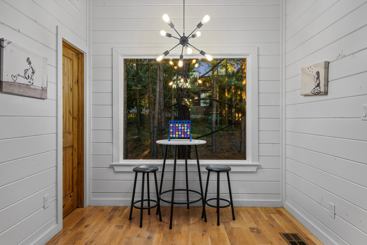 A quiet seating nook for two with a high table and chairs in front of a large window — the perfect spot to enjoy morning coffee while taking in the peaceful view. ☕