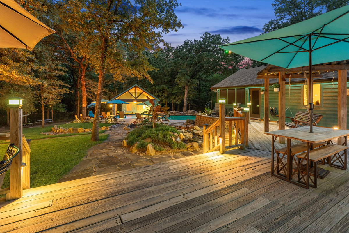 Sitting on the deck at night is pure magic. The soft glow of the exterior lighting creates a perfect balance—bright enough to see, yet dim enough to relax. Enjoy the massive deck's glider rocker, porch swing, hammock, and swivel chairs for ultimate comfort
