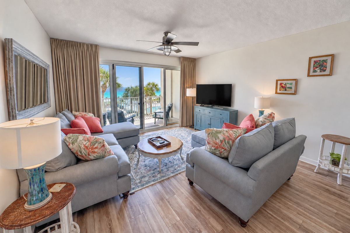 Living room with updated seating, a TV, and direct balcony access with Gulf views.