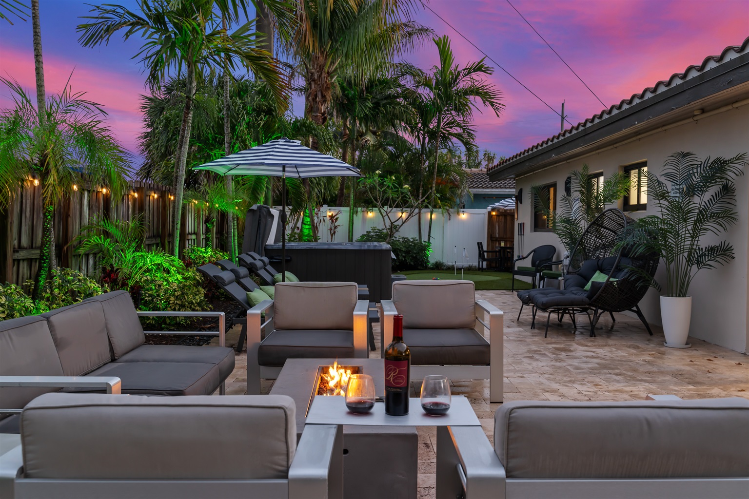🔥 Unwind under the palm trees with wine by the fire — then sink away in the 7 person hot tub.