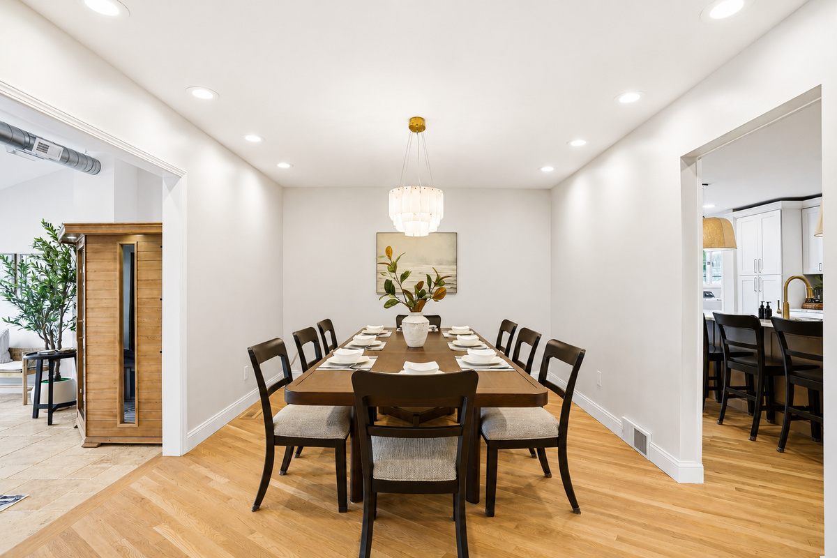 Elegant dining room with a large table, modern seating, and clean minimalist design. Bright, open space ideal for family meals, gatherings, and entertaining in a stylish, upscale setting.