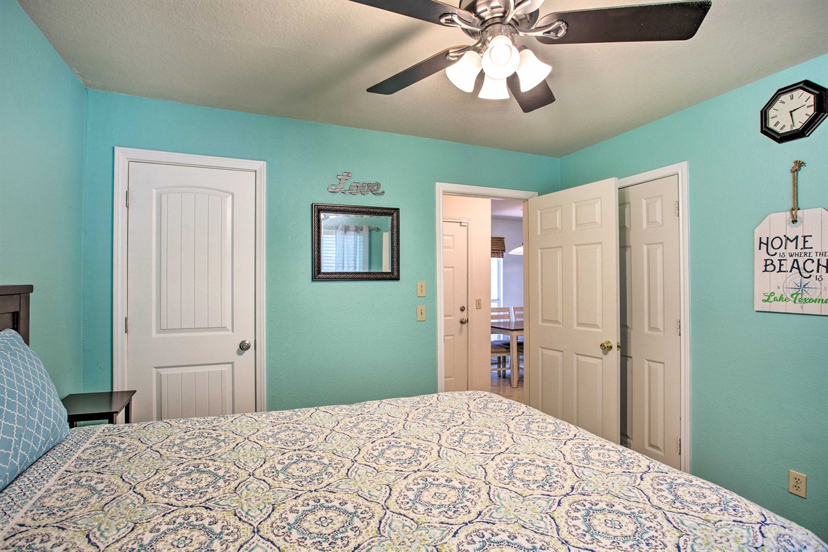 Master bedroom with queen size bed, walk in closet, and attached bathroom.
