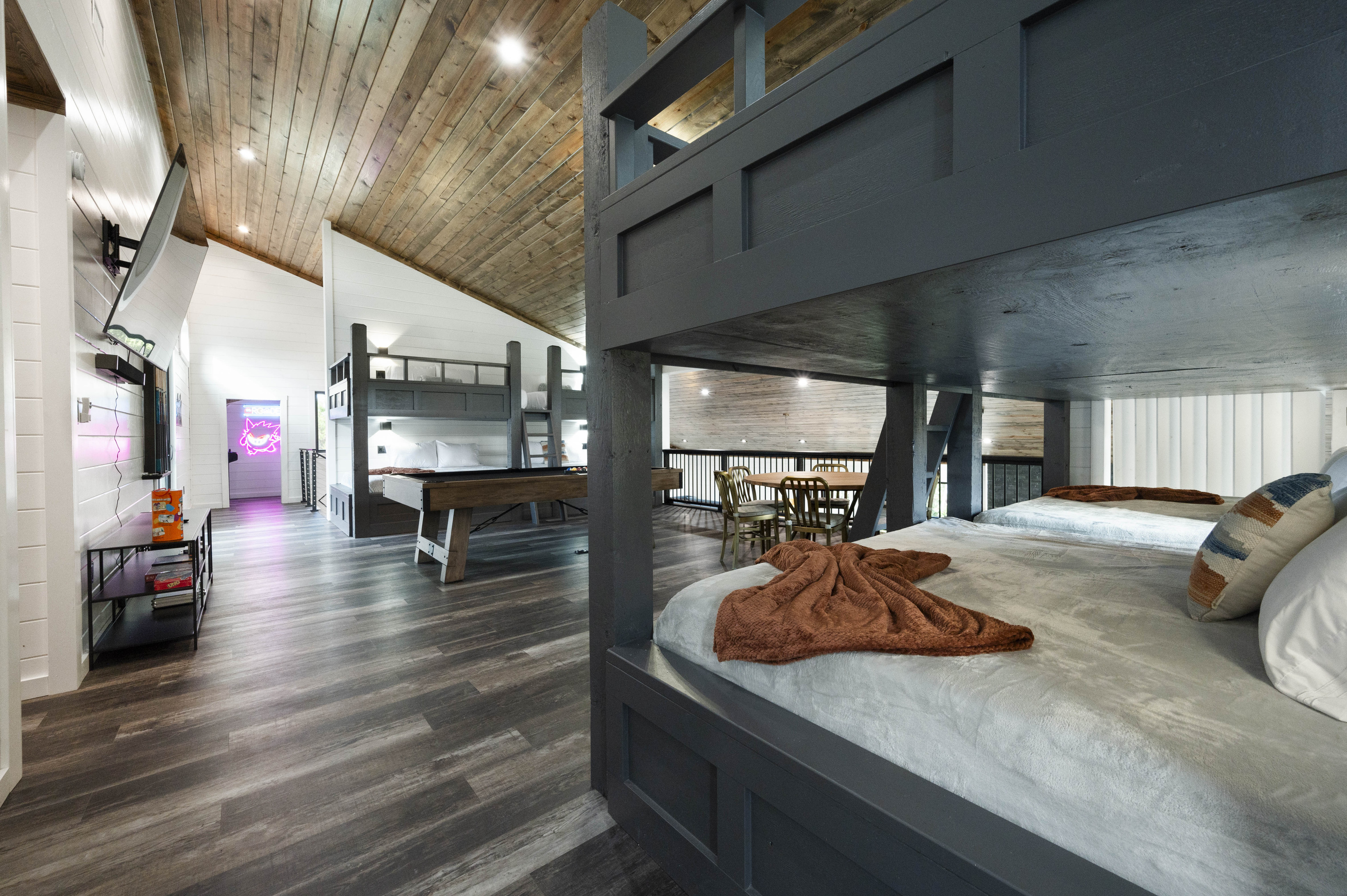 The game room, complete with a pool table, television, and game table, is a paradise for entertainment enthusiasts