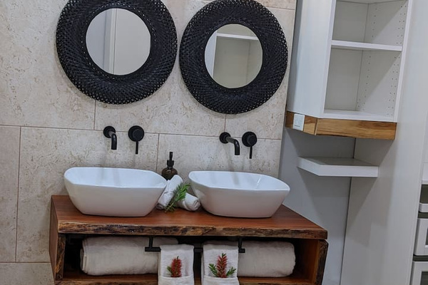 Here is our dual vanities in the primary bath. We made the vanity base out of a single piece of Mahogony. Super fun project and we love the live edge and organic variaton of the lines. 