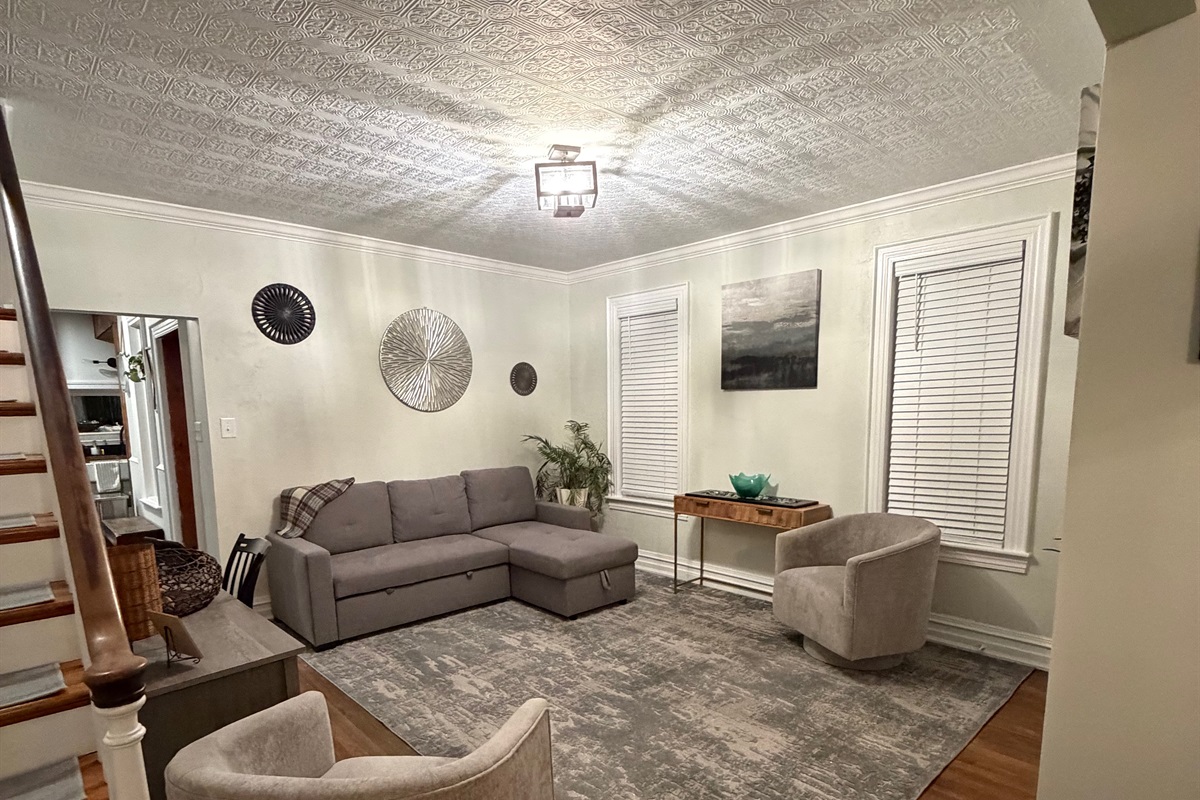 secondary living room with a sleep pull out couch and accent chairs.