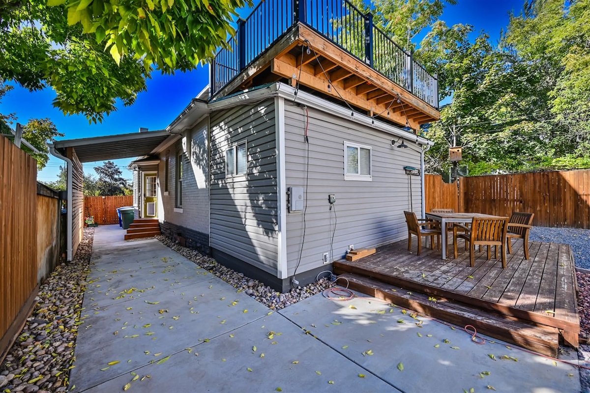 Backyard with a covered patio and deck.  Gather out back  — whether you're sipping cocoa or star-gazing, it’s made for relaxed evenings.