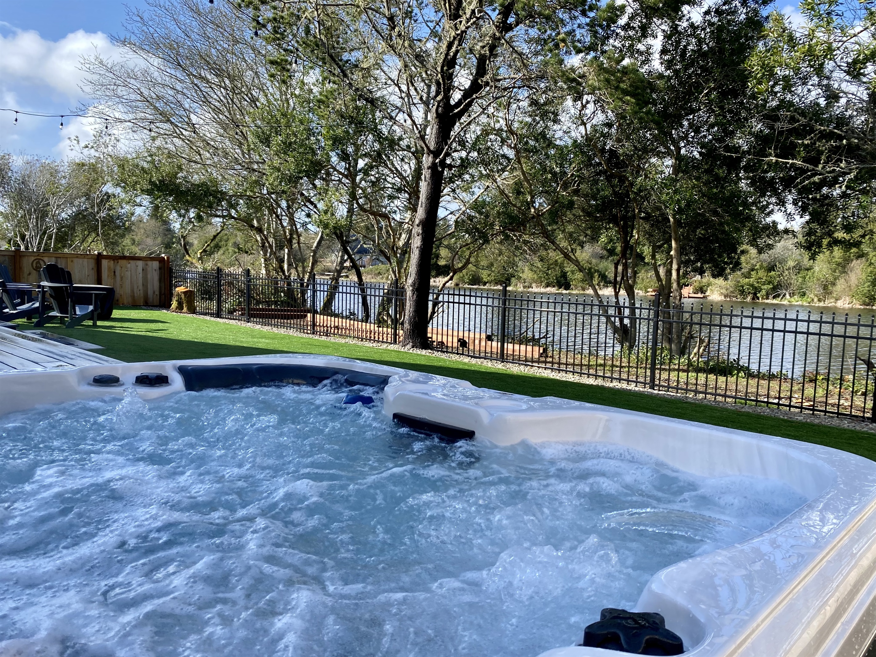 Slide into the hot tub as the canal drifts by behind the trees — jets on, stars out, day officially over.