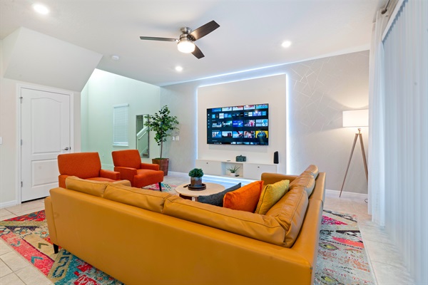 Bright and spacious living room with large windows, plush seating, and a smart TV—perfect for relaxing after theme park days.