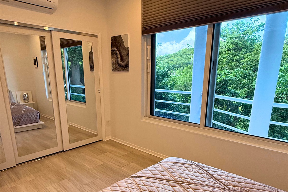 A queen sized bed and large windows in the guest room