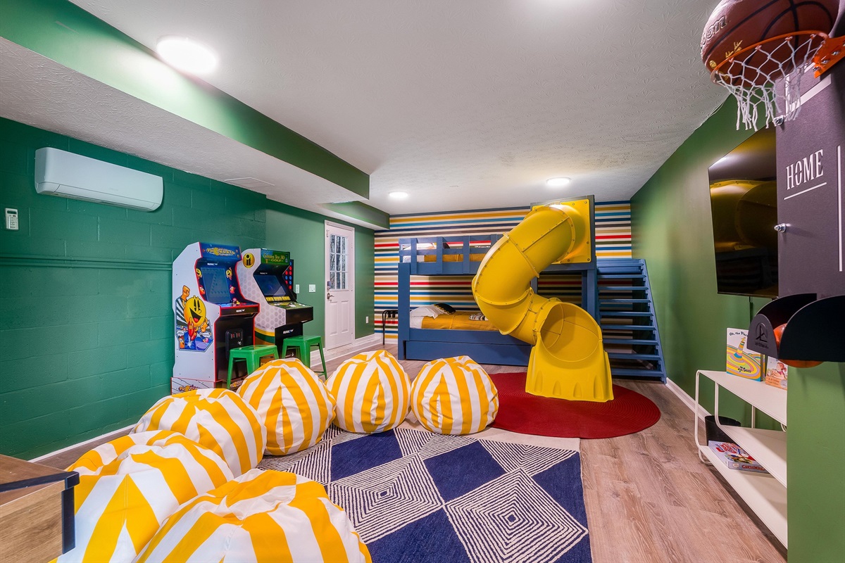 The room kids run to first — bunks, arcade games, beanbags, and a twisty slide they’ll talk about for weeks.