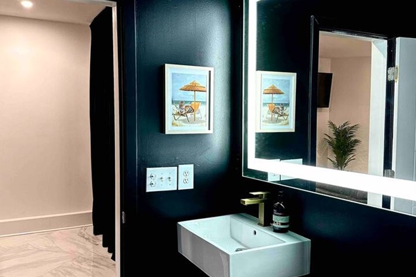 Large LED mirror and sleek finishings for the private bathroom.
