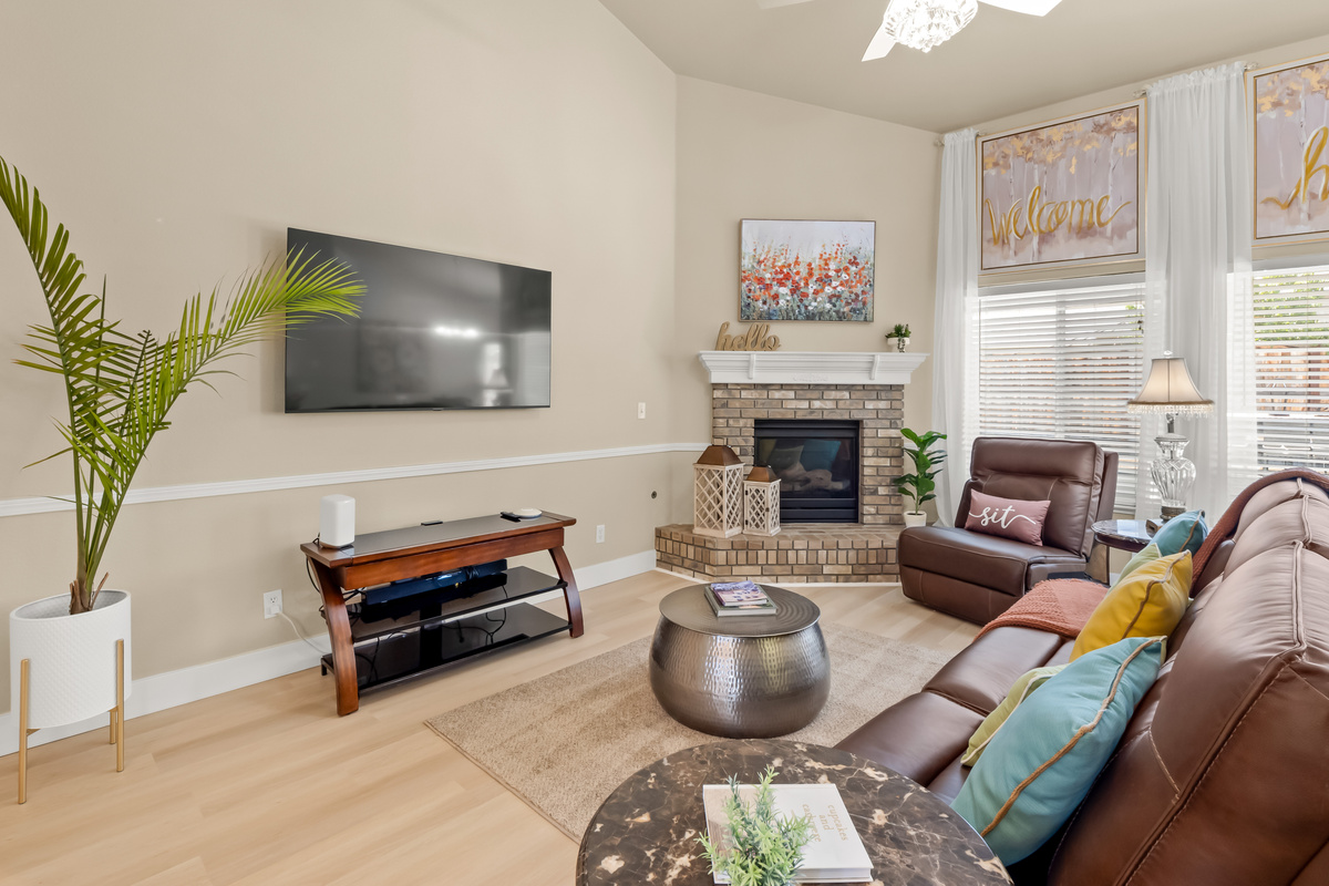Spend quality time with family and friends in this inviting living room, where natural light pours through oversized windows and the fireplace creates the perfect atmosphere for relaxing evenings at home.