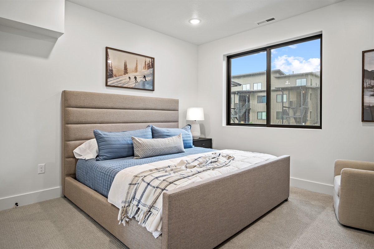 Wake up to natural light in a stylish king bedroom with ample storage and soft, inviting linens.