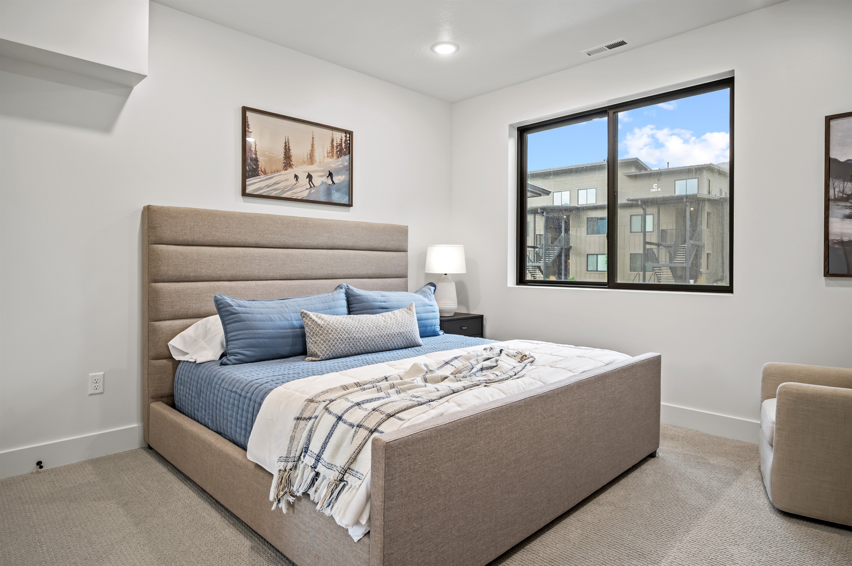 Wake up to natural light in a stylish king bedroom with ample storage and soft, inviting linens.