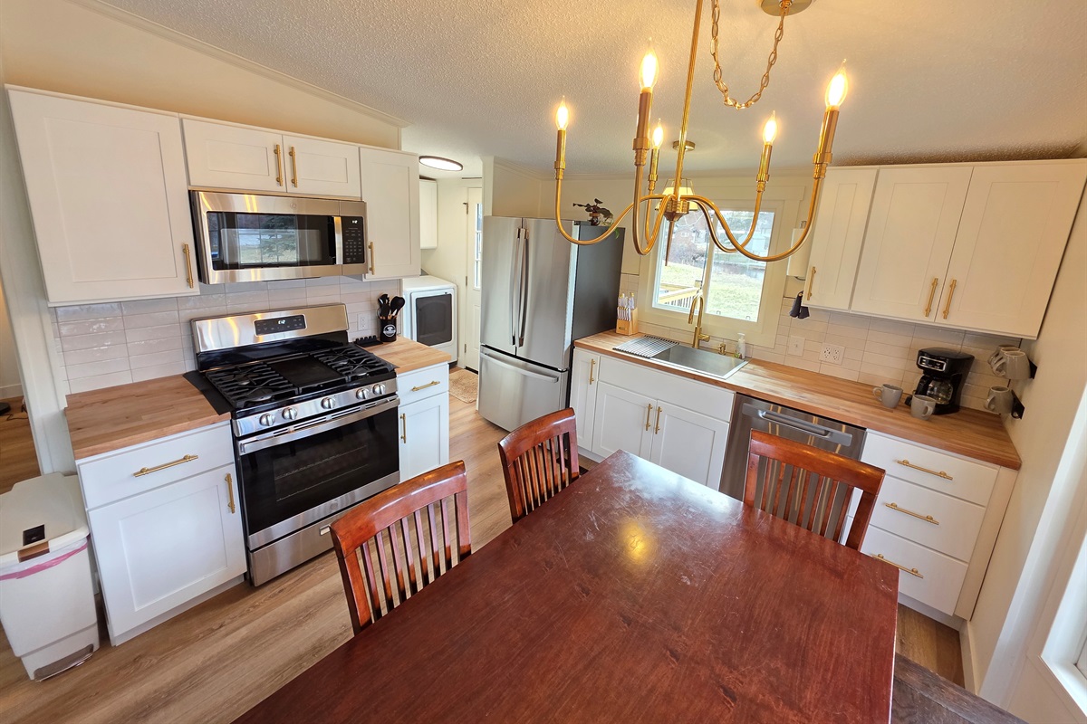 Kitchen  with stainless steel appliances 
and dining area.