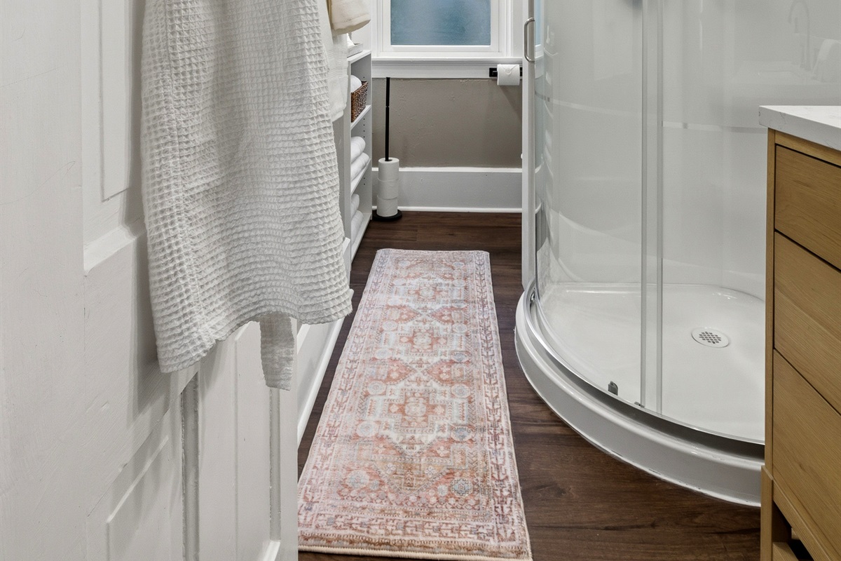 Glass-enclosed corner shower with spa-style waffle robe for comfort!