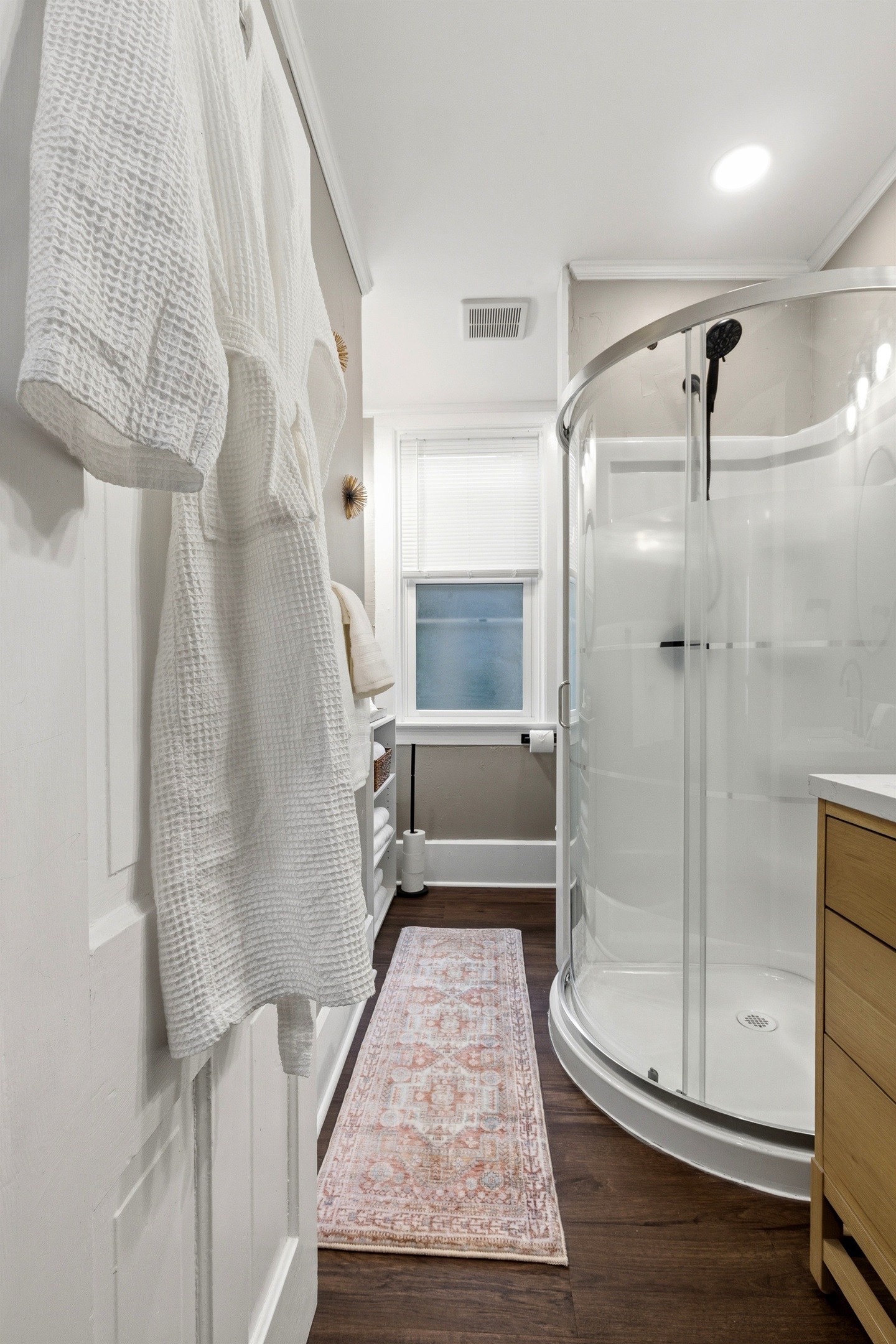 Glass-enclosed corner shower with spa-style waffle robe for comfort!