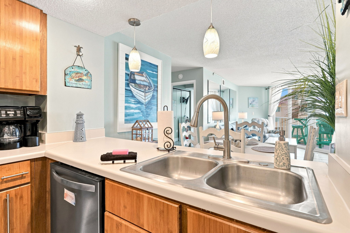 Stainless double sink and ample counter space overlooking the open living and dining area.