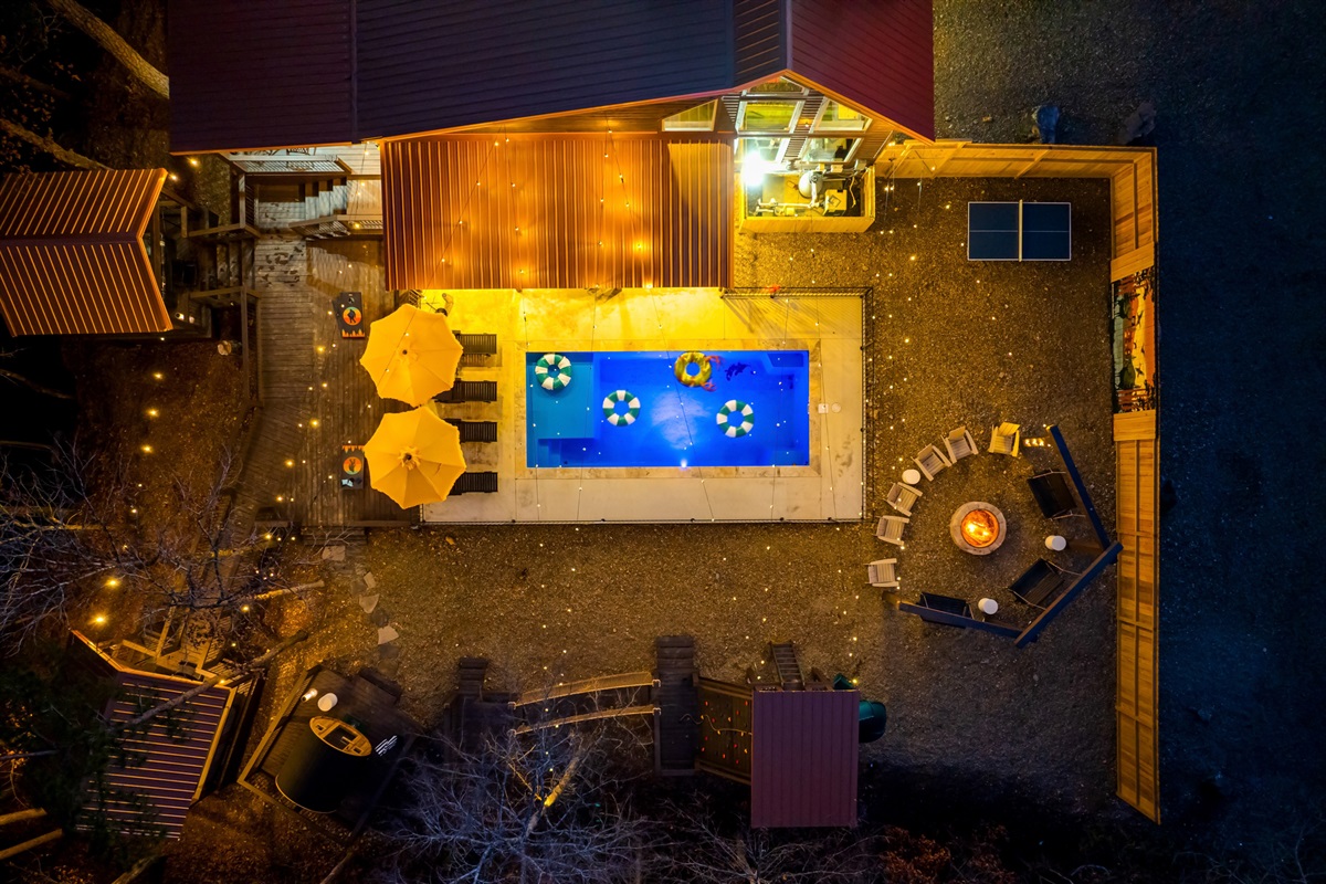 Outdoor Oasis: Dive into fun with a shimmering pool, cozy seating, and twinkling lights!