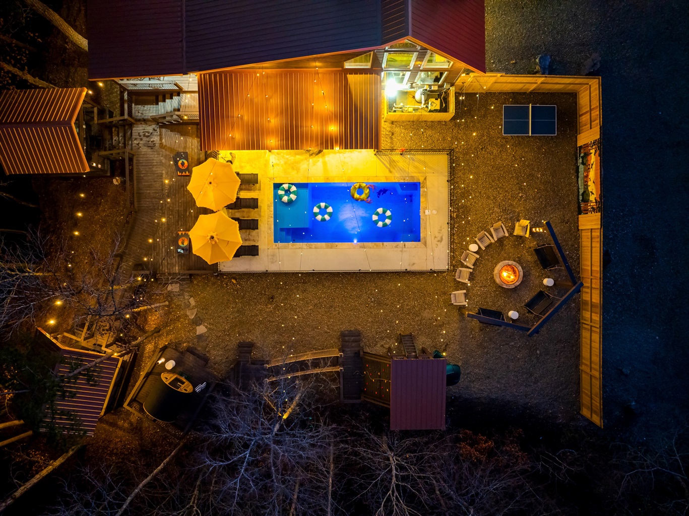 Outdoor Oasis: Dive into fun with a shimmering pool, cozy seating, and twinkling lights!