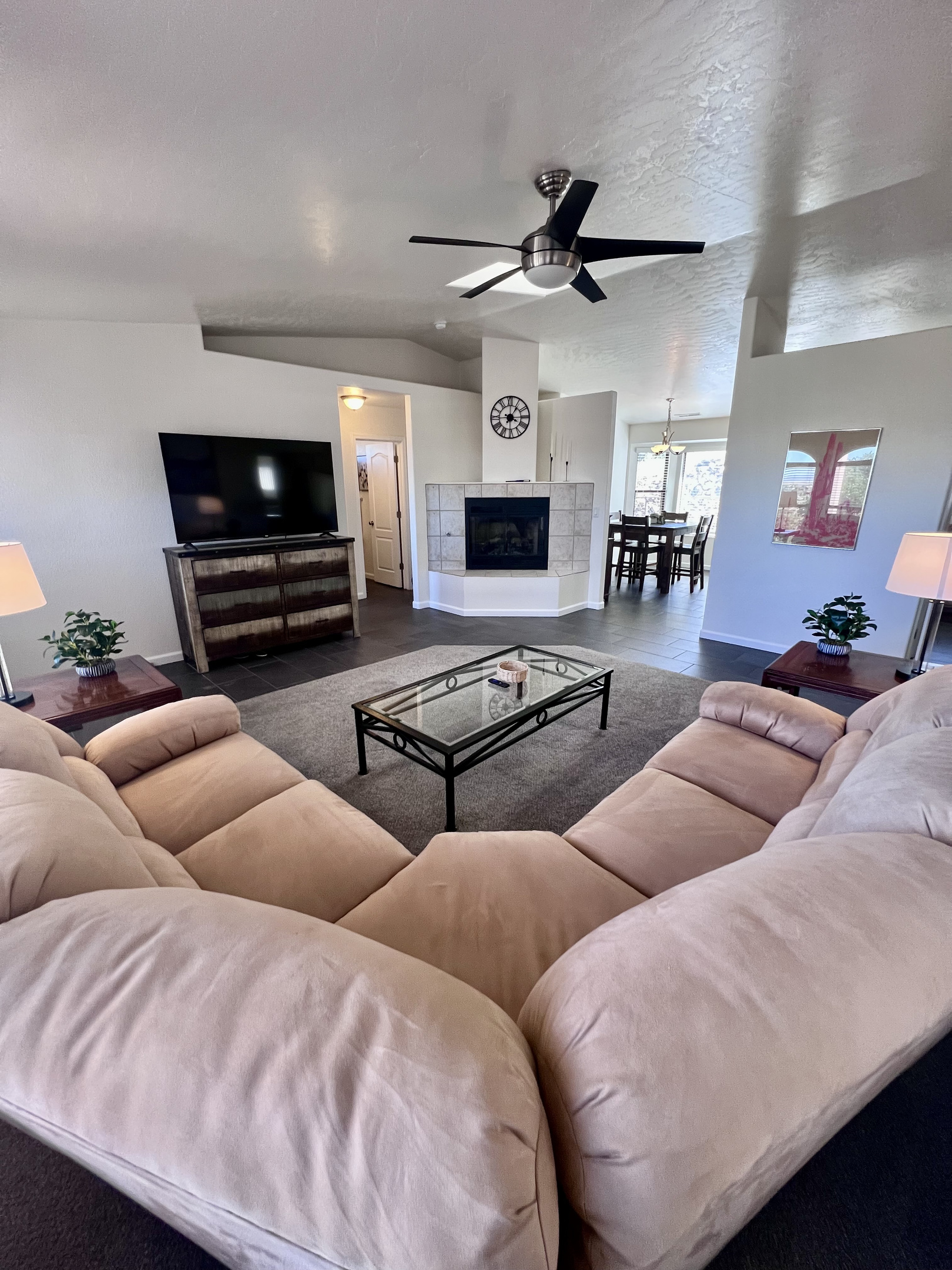 This expansive living room offers plenty of space for everyone to spread out and relax. Whether you're curling up by the fire with a good book, watching a movie on the  60-inch Smart TV, or enjoying game night with friends, this space has it all