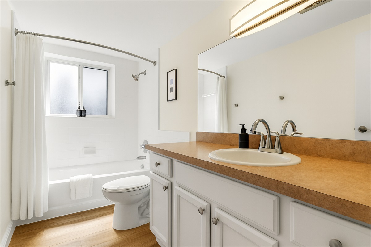 Freshly updated bathroom with granite vanity, stylish fixtures, and full-length mirror.