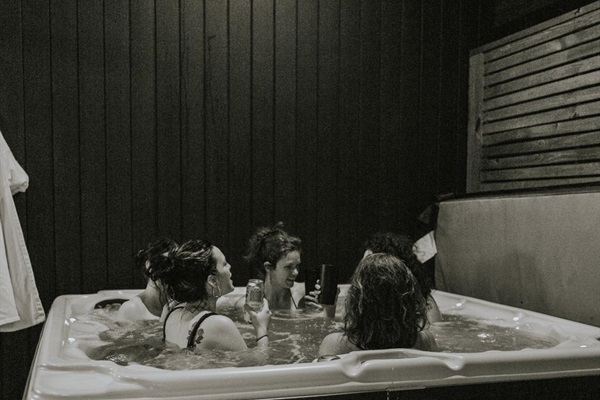 Glass House hot tub nights—soak, sip, and stay awhile 🖤✨