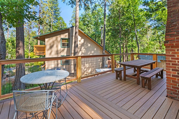 Enjoy morning coffee or evening meals on this sunny deck, surrounded by tall pines.