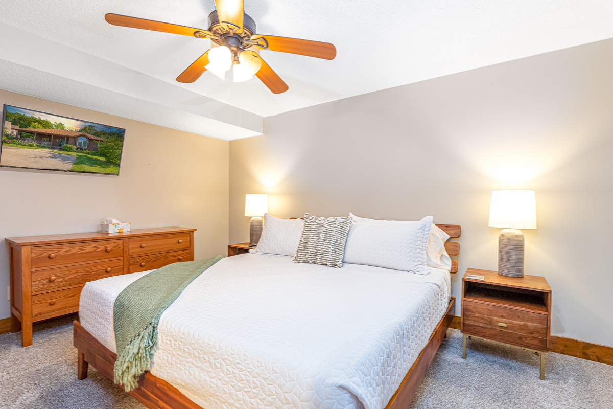 Bedroom 5 featuring a King bed and a Roku Smart TV, and an ensuite bathroom; one of three bedrooms located on the lower level.