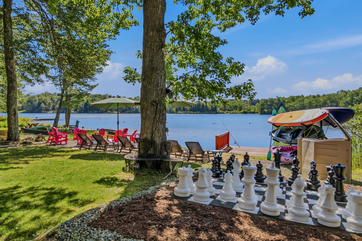 Lakefront lawn with giant chess set, lounge chairs, and direct access to Lake Carobeth