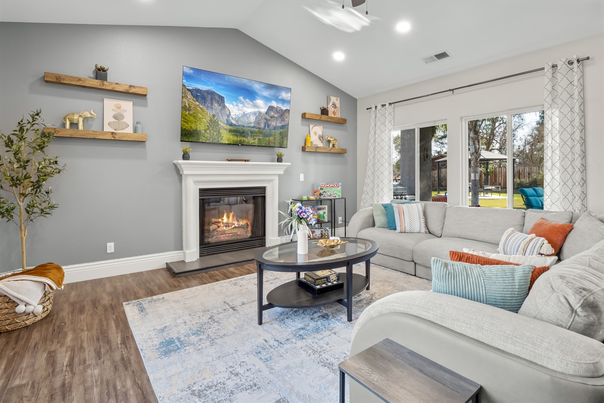 Spacious and welcoming living area with a cozy fireplace, large smart TV, and comfortable sectional seating—perfect for movie nights, board games, and quality time together.