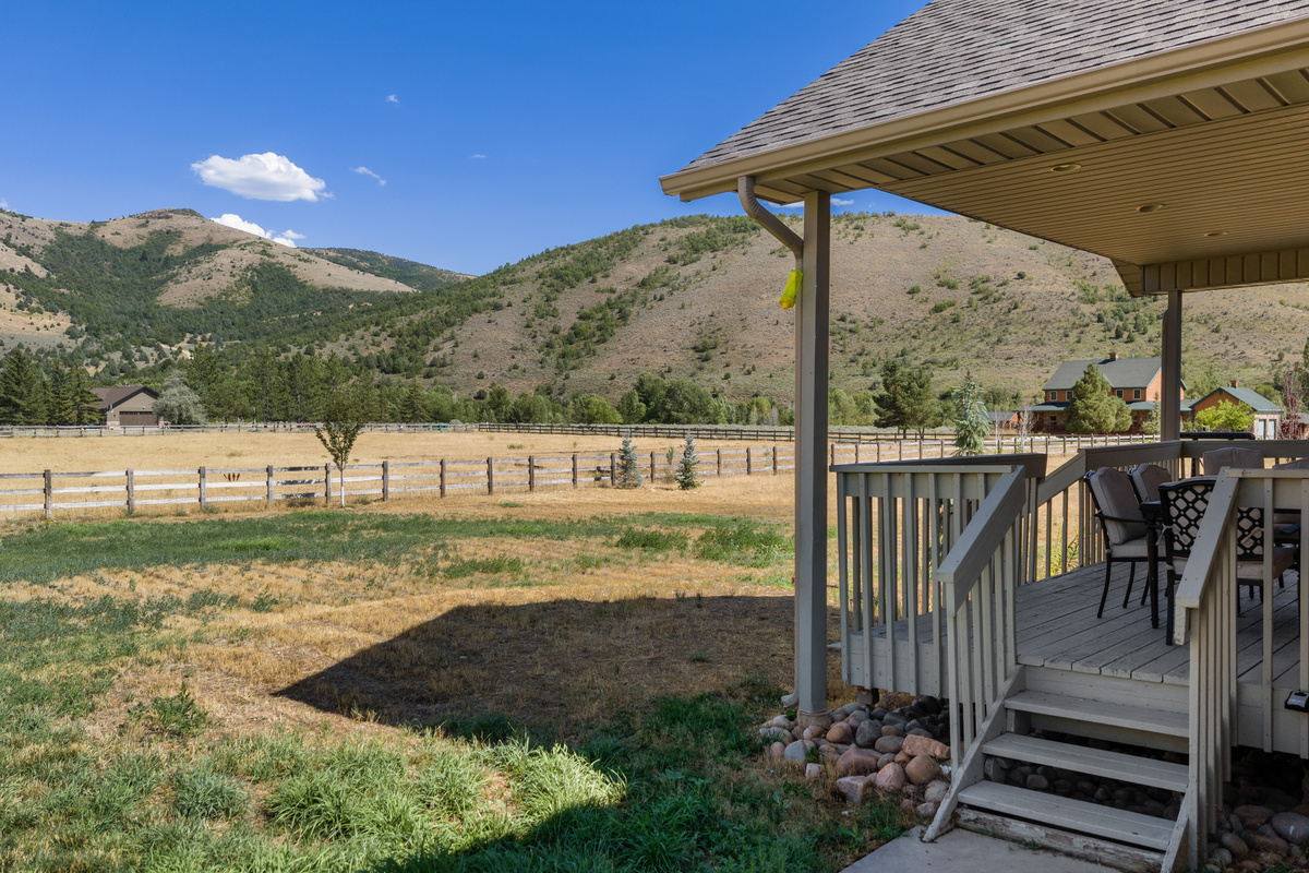 A covered outdoor terrace opens to sweeping mountain and valley views, offering a serene setting for morning coffee, quiet conversation, or an afternoon outdoors.