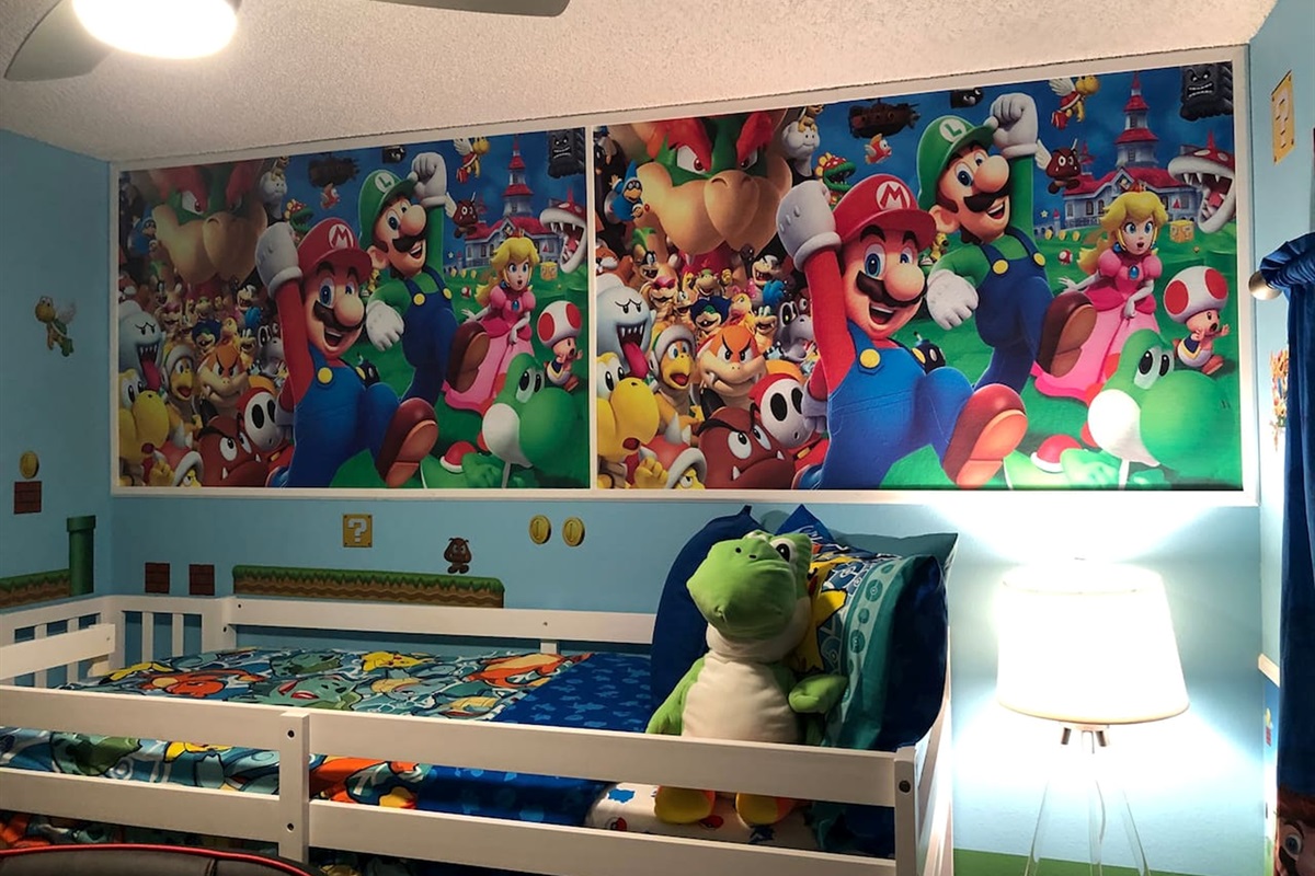 Twin bunkbed room , a playful children's bedroom featuring a Mario themed wall mural and bedding.