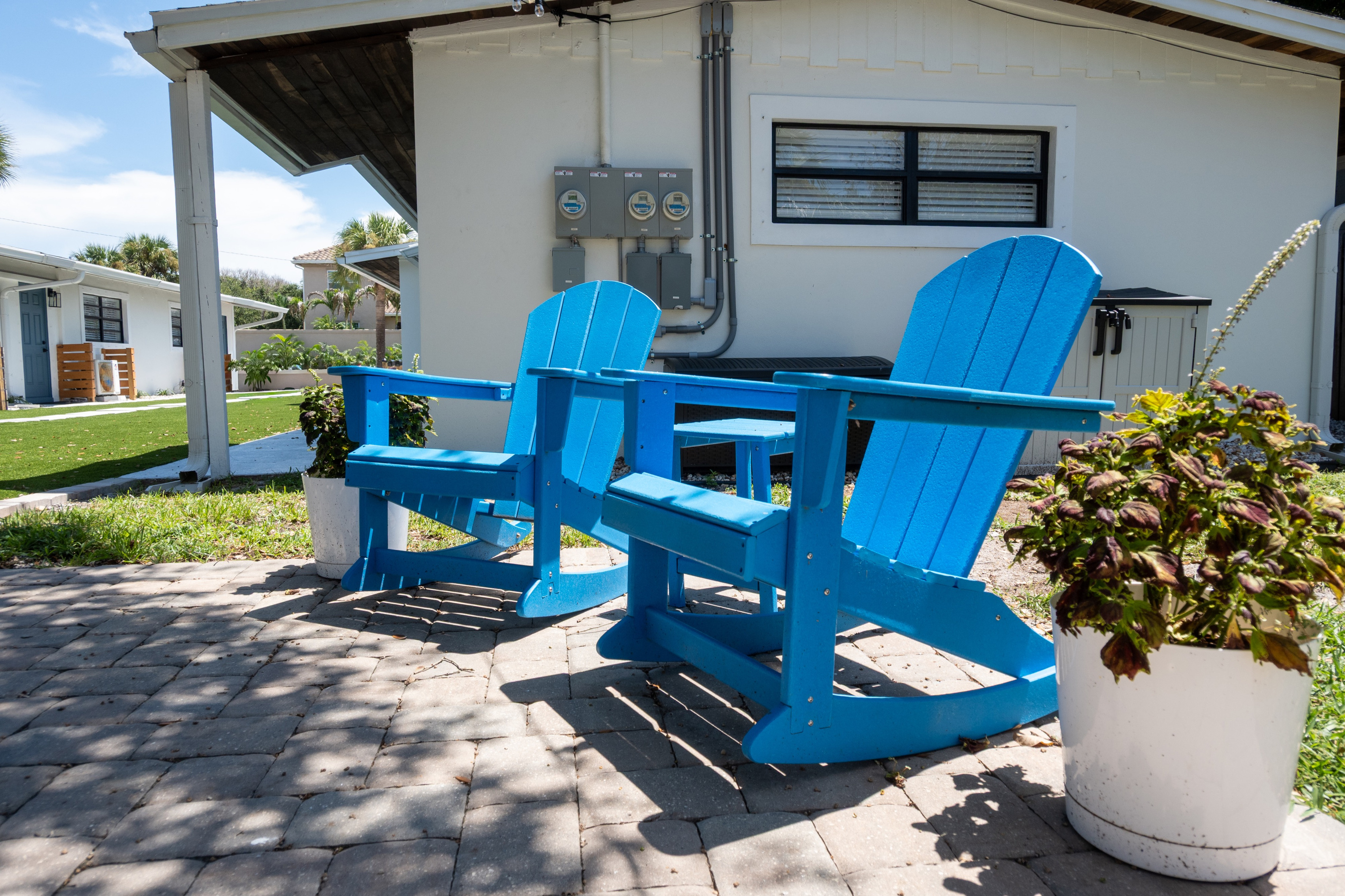 Shared courtyard seating with blue Adirondack chairs