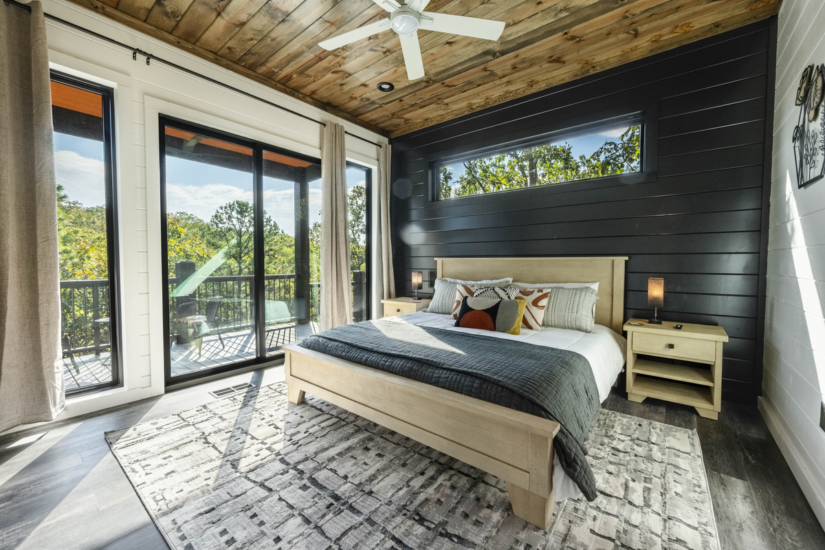 Bedroom designed with an inviting decor, cozy bedding and large windows with an attached patio to step out and enjoy nature!