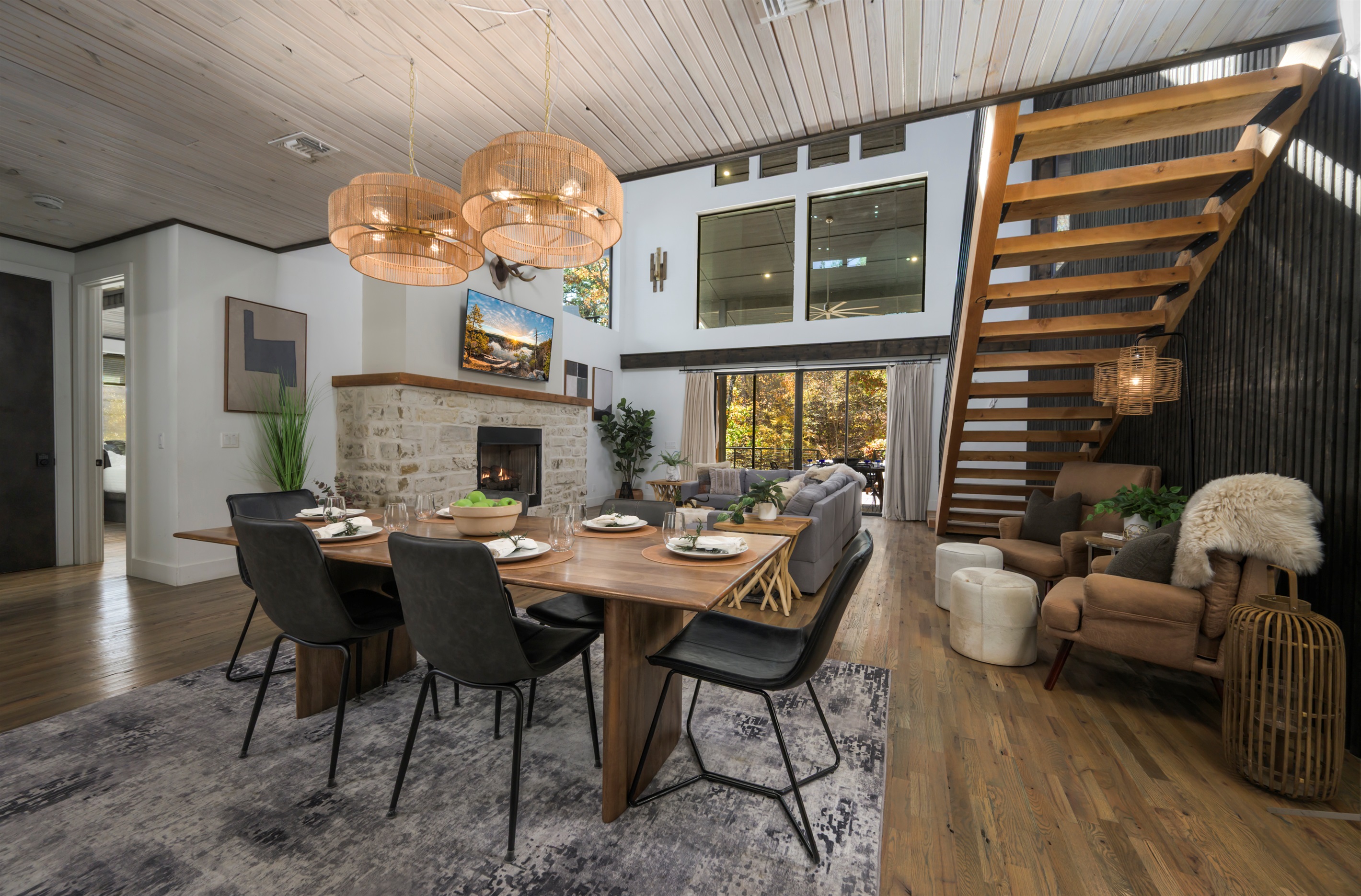 Experience luxury cabin living in Hochatown with vaulted ceilings, modern design, and a cozy stone fireplace.